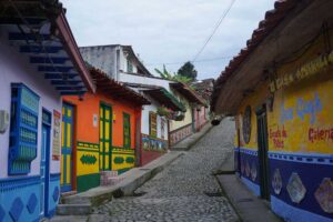 Lugares cerca a Medellín para visitar. En la foto una calle de Guatapé con casas coloridas a lado y lado.